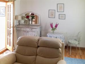 un soggiorno con un divano e uno specchio di Honeysuckle Cottage a Springside