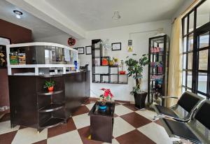 a room with a salon with a chair and a table at Hotel posada Juquila in Zacatlán