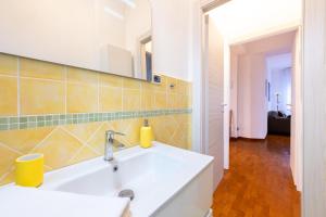 a bathroom with a white sink and a mirror at Blu&Yellow Apartment in Parma Station in Parma +16 photos