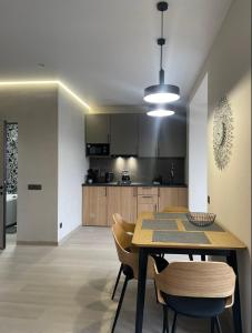 a kitchen and dining room with a table and chairs at Свіжі апартаменти в центрі міста новобудові на Проскурівське підпілля 110а in Khmelnytskyi