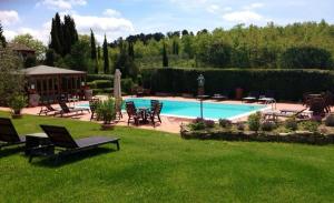 a swimming pool in a yard with lawn chairs at Villa Chiccheio Rooms in Montepulciano