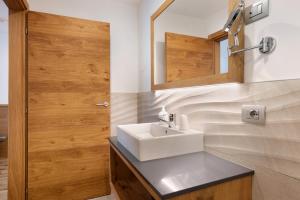 a bathroom with a sink and a mirror at Relais Dolomiti in Bedollo +36 photos