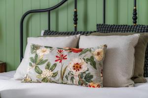 ein Bett mit zwei Kissen und grünen Wänden in der Unterkunft Casa da Madrinha in Fenais da Ajuda