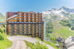 a building on top of a dirt hill with a mountain at Résidence Pierre & Vacances Capella in Avoriaz