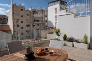 a table with a croissant on top of a balcony at Athens Soho Lofts -Evaggelistrias 18 in Athens
