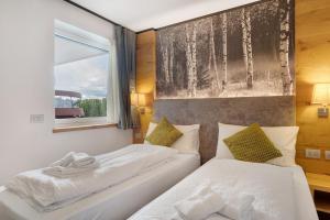 two beds in a room with a window at Relais Dolomiti in Bedollo