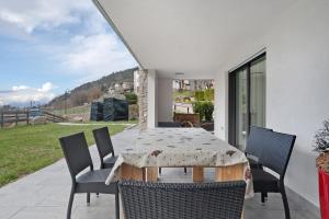 a table and chairs on a patio with a view at Relais Dolomiti in Bedollo
