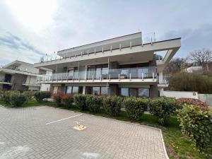 Un edificio con un estacionamiento enfrente. en Fehér Hullám Apartman, en Balatonalmádi