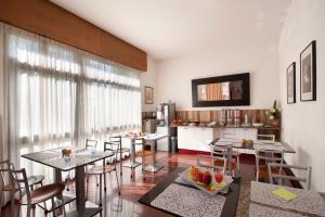 ein Wohnzimmer mit Tischen und Stühlen und eine Küche in der Unterkunft Hotel Caselle in San Lazzaro di Savena