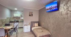 a bedroom with a bed and a kitchen with a table at Apartmani IMW in Zaječar