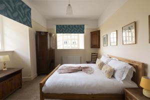 a bedroom with a bed with white sheets and pillows at Bishop Lightfoot Cottage in Bishop Auckland