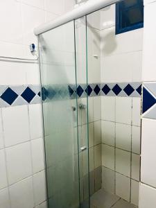 a glass shower in a bathroom with blue and white tiles at Pousada Recanto da Chapada in Mucugê +60 photos