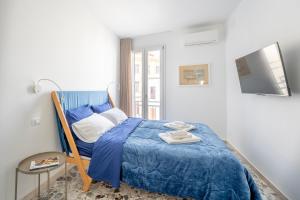 ein Schlafzimmer mit einem blauen Bett und einem Fenster in der Unterkunft Eos Serenity Suites in Syrakus