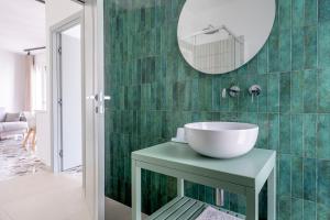 ein Badezimmer mit Waschbecken und Spiegel in der Unterkunft Eos Serenity Suites in Syrakus + 58 Fotos