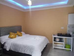 a bedroom with a bed with yellow pillows at Hemison Homes in Naivasha