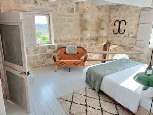 una camera da letto con un letto, una sedia e una finestra di Les Terrasses de Flaugnac a Flaugnac