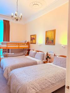 une chambre avec trois lits dans une pièce dans l'établissement Europa House Hotel, London Paddington, à Londres