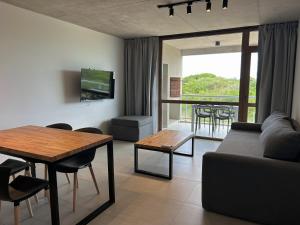 a living room with a couch and a table at Jade Residencias de Mar in Villa Gesell