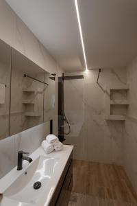 a white bathroom with a sink and a shower at Athens Soho Lofts -Evaggelistrias 18 in Athens +52 photos