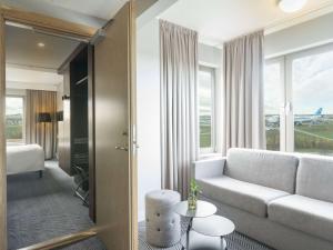 salon z kanapą i oknem w obiekcie Radisson Blu Arlandia Hotel, Stockholm-Arlanda w mieście Arlanda