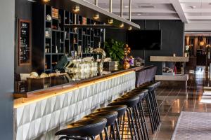 a bar with black leather stools in a restaurant at Radisson Blu Arlandia Hotel, Stockholm-Arlanda in Arlanda