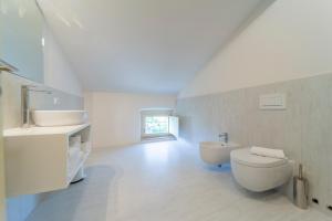 a white bathroom with a toilet and a sink at Al Torrione in Collecchio +30 photos