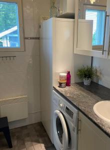a white refrigerator in a kitchen with a washing machine at Rantahelmi-huvila in Eurajoki