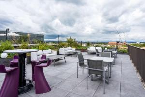 a patio with tables and chairs on a roof at Prize by Radisson, Bern City in Bern