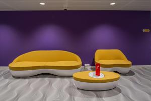 two yellow beds and a table in a room at Prize by Radisson, Bern City in Bern +84 photos