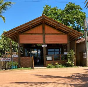 a wooden building with a sign in front of it at Pousada da Vila restaurante in Corumbau