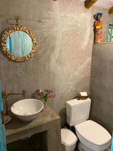 a bathroom with a white toilet and a sink at Pousada da Vila restaurante in Corumbau