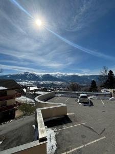 a view of a parking lot with the sun in the sky at Studio chaleureux à Font-Romeu in Font-Romeu