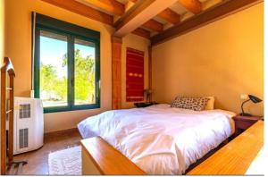 MejoradaにあるLa encina del pastorの大きなベッドと窓のある寝室