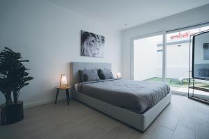 une chambre avec un grand lit et une grande fenêtre dans l'établissement Villa Paradise 2, à Mariquiteira