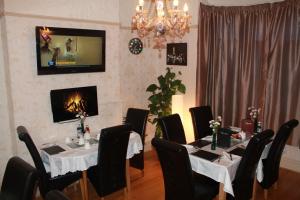 a dining room with tables and chairs and a chandelier at The Comat in Cleethorpes