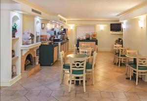 a restaurant with tables and chairs and a counter at Rodeway Inn in College Station