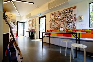 a room with a guitar and a table and chairs at YHA Jockey Club Mt. Davis Youth Hostel in Hong Kong