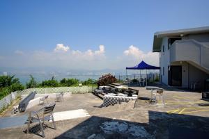 un patio con sillas y una sombrilla azul en un edificio en YHA Jockey Club Mt. Davis Youth Hostel, en Hong Kong