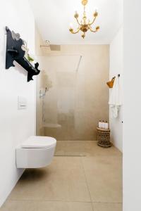 a bathroom with a toilet and a chandelier at Plaza España 5 Casa con encanto, terraza y vistas in Vejer de la Frontera