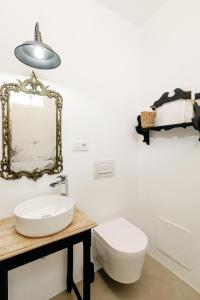 a bathroom with a sink and a toilet and a mirror at Plaza España 5 Casa con encanto, terraza y vistas in Vejer de la Frontera +20 photos