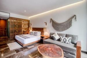 a bedroom with a bed and a couch and a table at Central Location and 3 pools in Tulum