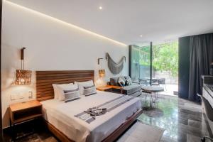 a bedroom with a large bed and a living room at Central Location and 3 pools in Tulum