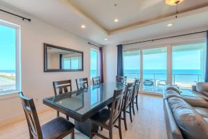 a dining room with a table and chairs and a couch at 5 BEDROOM BEACHFRONT CONDO - 4th Floor in South Padre Island