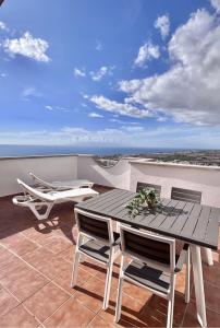a patio with a table and chairs on a balcony at Ocean View Haven, Perla Del Mar in Adeje