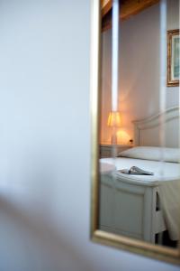 espejo reflejo de un dormitorio con cama en Hotel Caselle, en San Lazzaro di Savena