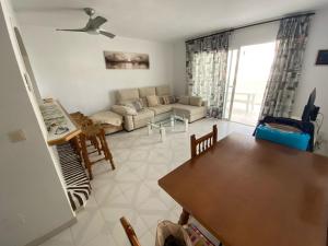 a living room with a couch and a table at Spacious, calm and bright Duplex Apartment in Private Residence ideal for families, beach and golf in Sitio de Calahonda