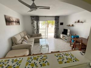 a living room with a couch and a table at Spacious, calm and bright Duplex Apartment in Private Residence ideal for families, beach and golf in Sitio de Calahonda