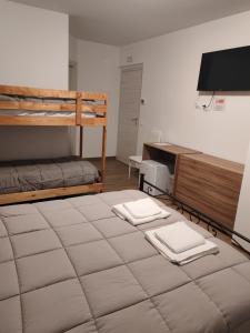 a room with a bed and a bunk bed with two towels at La Locanda del Voltigno in Villa Celiera