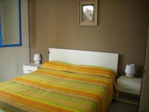 Villetta Mare في Terrauzza: غرفة نوم مع سرير وبطانية مخططة ملونة