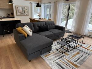 ein Wohnzimmer mit Sofa und Tisch in der Unterkunft BLOOM - Luxe et Confort en forêt in Valcartier Station + 41 Fotos
